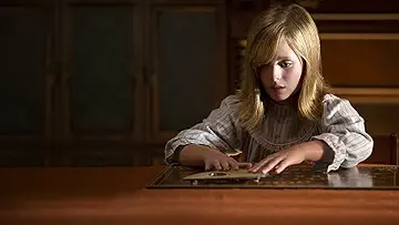 Doris Zander (Lulu Wilson) levitates in front of a Ouija board in the Ouija: Origin of Evil game