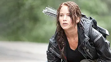 Katniss Everdeen drawing her bow in the arena in The Hunger Games game.