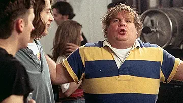 Chris Farley as Tommy Callahan holding a model car in front of David Spade as Richard Hayden in the Tommy Boy game.