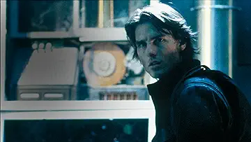 Tom Cruise as Ethan Hunt in sunglasses against an explosive background in the Mission Impossible II game.