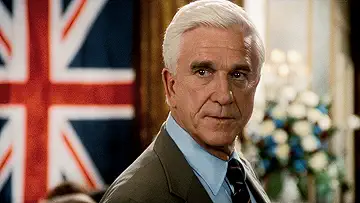 Leslie Nielsen as Frank Drebin holding a gun in the poster for The Naked Gun: From the Files of Police Squad! game.