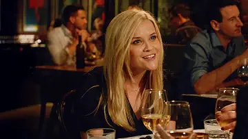 Reese Witherspoon smiling warmly while standing in a doorway in the Home Again game